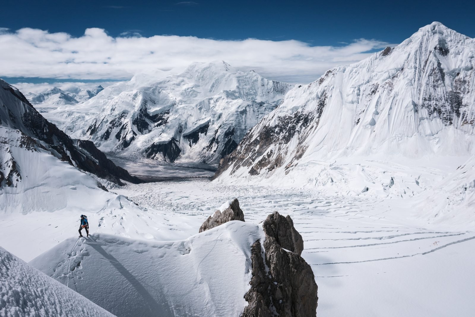 Climbers on a snow ridge above the glacier, Gasherbrum peaks behind