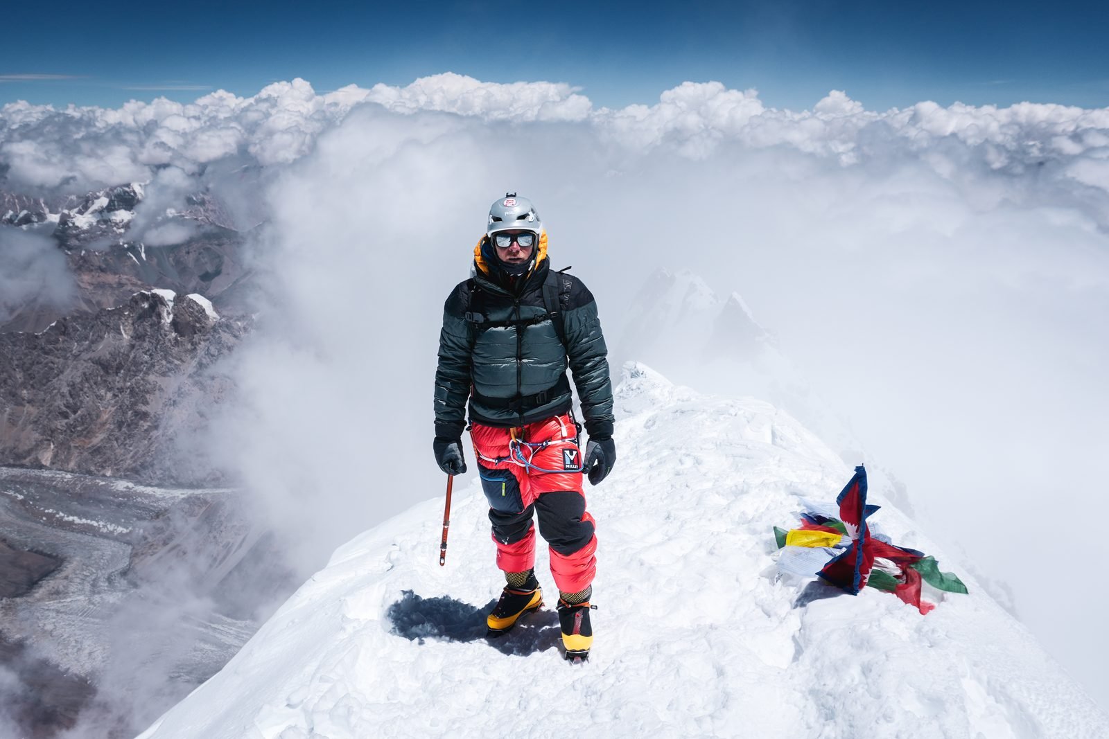 A climber with a headlamp at dawn
